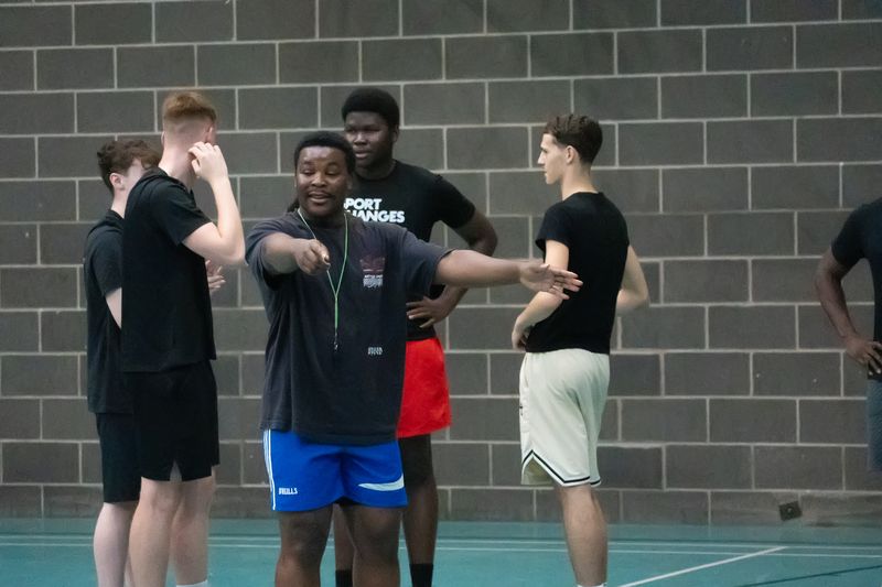 A coach explaining a drill to a group of players