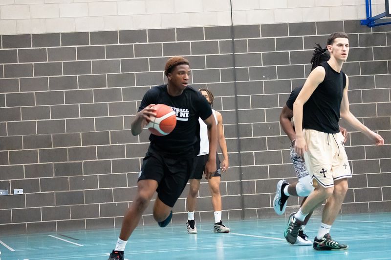 A player driving towards the basket with the ball in both hands