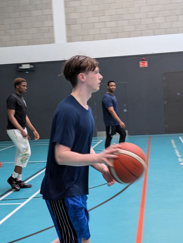 A player in a navy shirt looking up the court with the ball