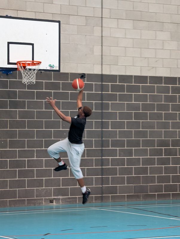 A player rising for a layup at the basket