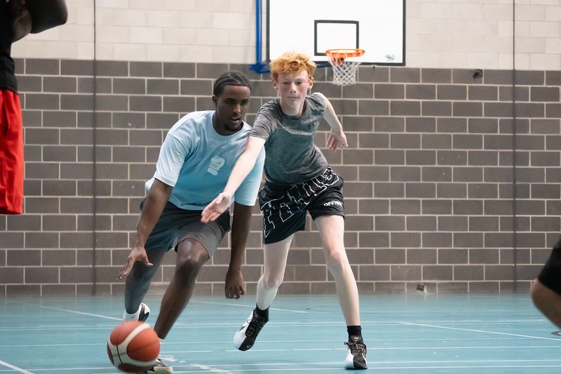A player driving low past a defender in a one-on-one drill