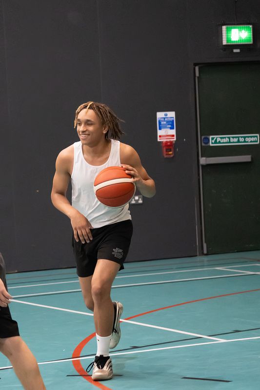 A smiling player bringing the ball up the court